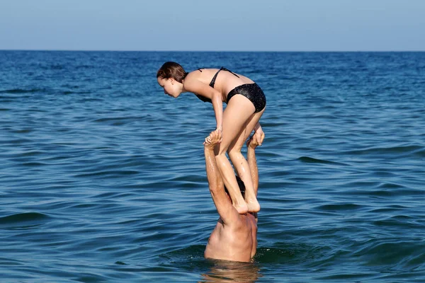Teenagermädchen Stürzt Von Den Schultern Eines Mannes Ins Wasser — Stockfoto
