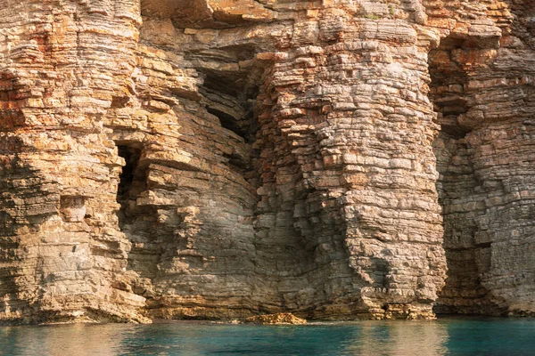Cerca acantilado del mar, rocas en capas y piedras con agua de mar azul turquesa — Foto de Stock