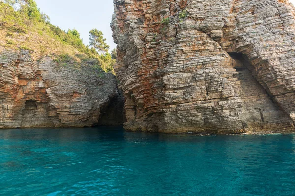 Cerca acantilado del mar, rocas en capas y piedras con agua de mar azul turquesa — Foto de Stock