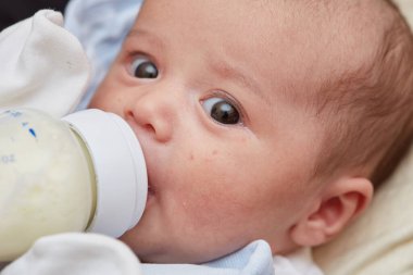 2 aylık yeni doğmuş bebek, yakın plan. Bebek maması var, şişeden süt var. Küçük bir odak alanı. seçici odak.