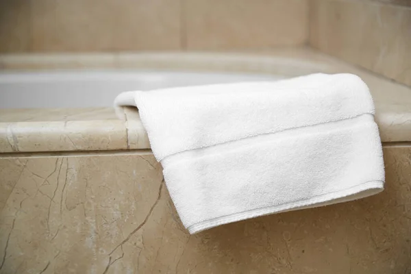 white clean foot towel on the edge of the bathroom.