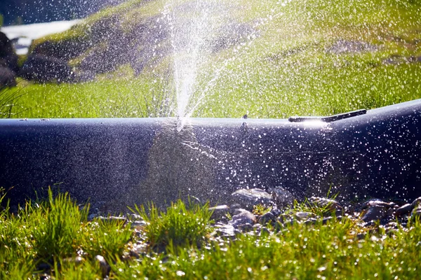 Hasarlı boru baskısı altında su sıçramalarına.