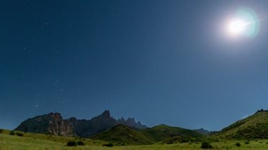 Ay 'ın gece gökyüzündeki hareketi dağların arka planına karşı