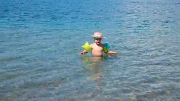 Pequeño niño sale del agua hacia el mar — Vídeos de Stock