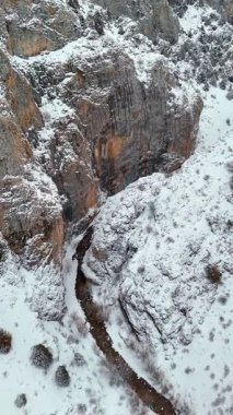 Donmuş nehir, karlı kayalar ve hava manzaralı görkemli kış kanyonu.