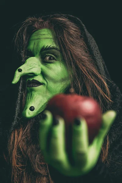 Bruja malvada sosteniendo una manzana roja — Foto de Stock