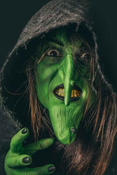 邪恶的女巫铸造在她兜帽下的诅咒 免版税图库图片