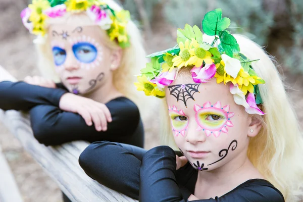 Hermanas gemelas de Halloween con maquillaje de cráneo de azúcar — Foto de Stock