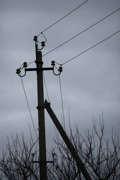 暗い曇りの空のワイヤと電気柱 — ストック写真