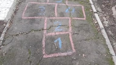 Asfalt yolda boyalı çocuklar seksek oyunu