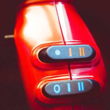 Siyah düğmeli kırmızı saç kurutma makinesinin bir parçası..