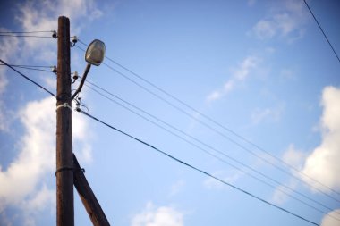 Mavi gökyüzünde lamba olan eski ahşap sütun