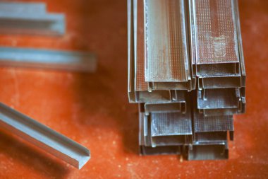 Kirli turuncu zeminde bir yığın yeni alçıpan profili.