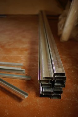 Kirli ahşap zeminde yeni alçıpan profilleri var.