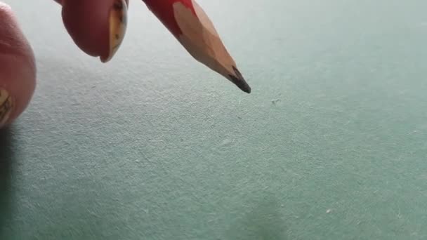 Un crayon de construction rouge dans les doigts des femmes fait une marque sur la cloison sèche verte. — Video