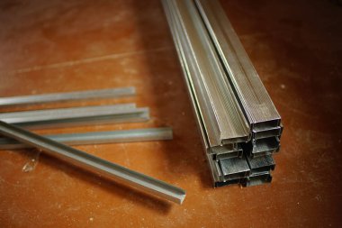 Kirli ahşap zeminde bir yığın yeni alçıpan profili var..