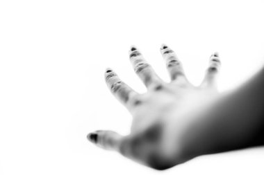 Beyaz arka planda, parmakları açık bir kadın eli. Güle güle jest. BW fotoğraf, bulanık yumuşak odak.