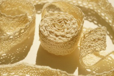 Hassas bej dantel, beyaz bir masanın üzerinde yakın plan..