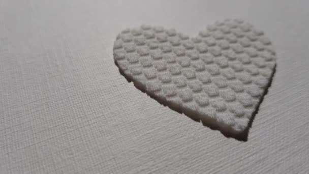 Roztomilé bílé srdce z texturovaného materiálu na stole — Stock video