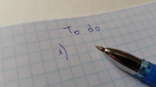 Text to do on checkered paper and blue pen. — Stock Video