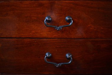 Kahverengi ceviz kaplamasından yapılmış bir masanın iki çekmecesi..