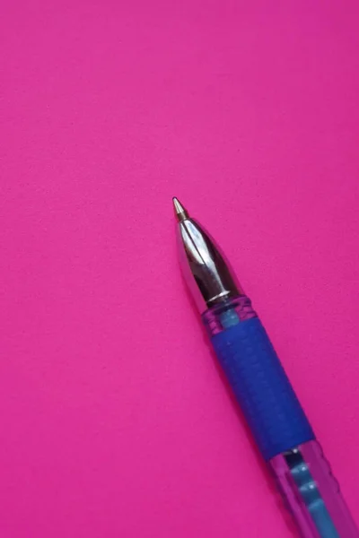 蓝色圆珠笔在鲜活的粉红纸上 — 图库照片