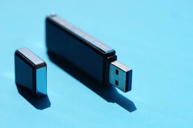 USB çubuğu güneşli mavi bir masada.