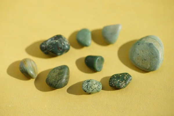 Set Green Pebble Stones Yellow Sunny Table — Stock Photo, Image