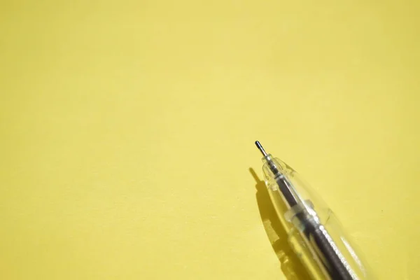阳光灿烂的黄纸上的圆珠笔 — 图库照片