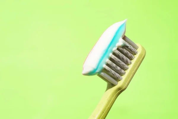 Escova Dentes Plástico Verde Com Pasta Dentes Listrada Fundo Verde — Fotografia de Stock