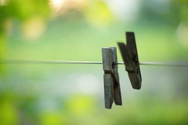 İki eski ahşap mandal bir yaz bahçesinde bir ipte asılı..