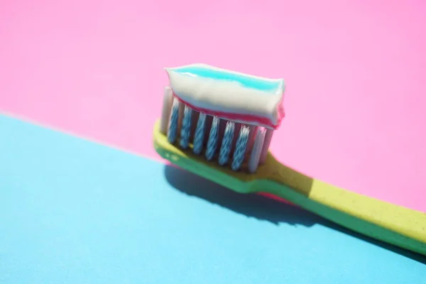 Spazzolino Plastica Verde Con Dentifricio Strisce Tavolo Blu Rosa — Foto Stock