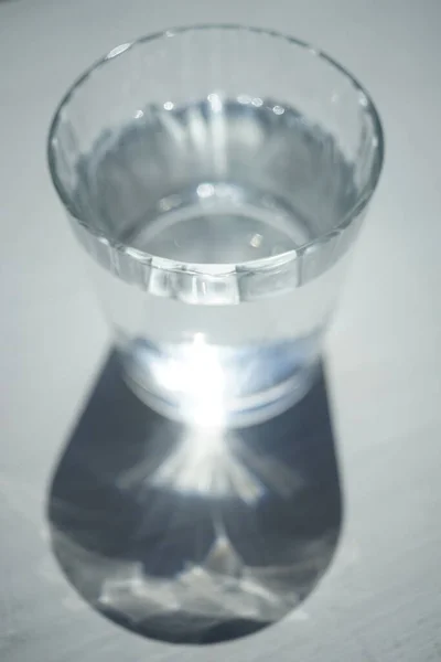 Γεμάτο Ποτήρι Νερό Λευκό Ηλιόλουστο Τραπέζι — Φωτογραφία Αρχείου