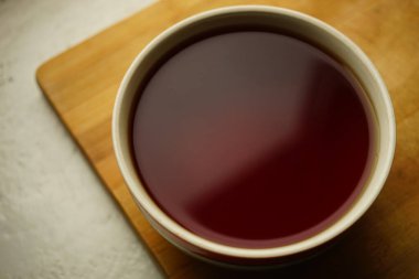 Tahtada siyah Seylan çayı olan büyük seramik bardak..