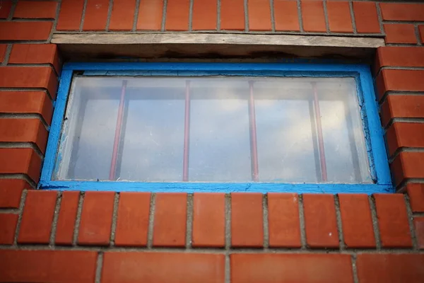 Low Window Blue Frame Iron Grating Brick Building — 스톡 사진