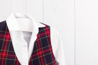 Bir erkek için okul üniforması askıda asılı.