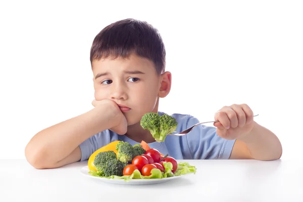 Мальчик ест овощи — стоковое фото