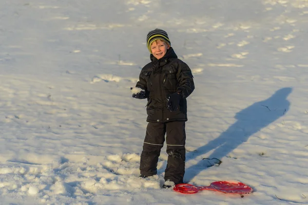 Portrait Happy little boy in winter clothing having fun in fresh white winter snow in evening light — Stock Photo, Image