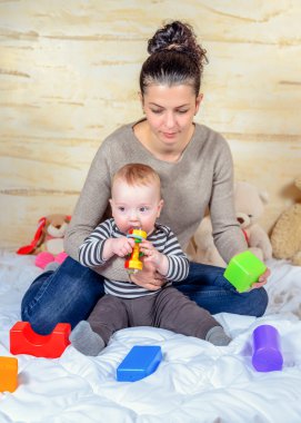 Anne ve bebek plastik blok evde oynarken