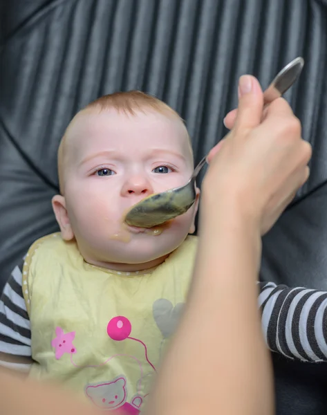 Bebê bonito na cadeira comendo alimentos saudáveis — Fotografia de Stock