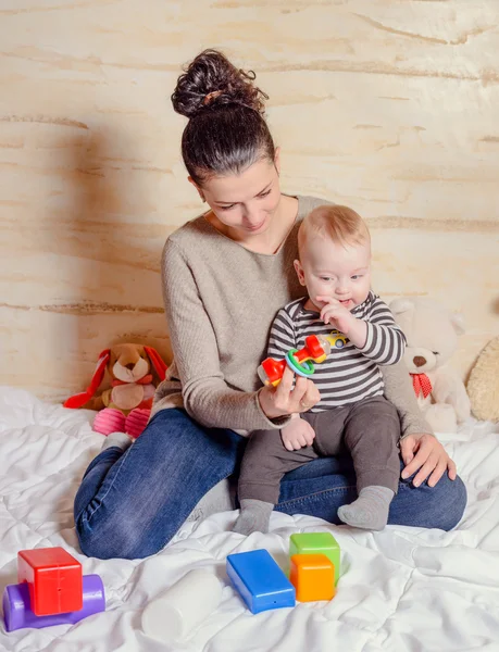 Hübsche Mutter mit ihrem kleinen Jungen lächelt in die Kamera — Stockfoto