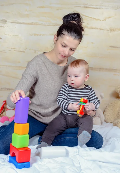 Anne ve bebek plastik blok evde oynarken — Stok fotoğraf