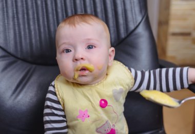 Yulaf lapası yemek ofis koltuğu üzerinde erkek bebek