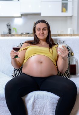 Şarap ve süt tutan hamile kadın