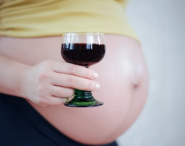 妊娠中の腹のクローズ アップとワインと手 — ストック写真