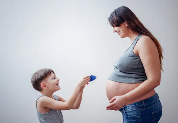 Happy boy giving pregnant woman a gift — Stock Photo, Image