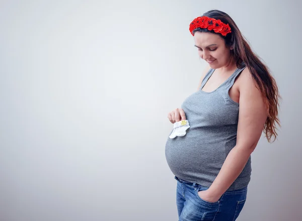 Pregnant woman holding baby socks — Stock Photo, Image