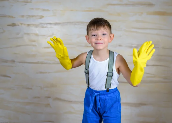 Cute boy in oversized rubber gloves — Stock Photo, Image