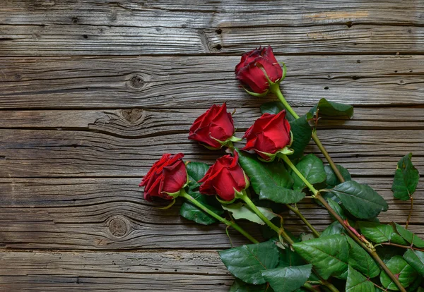 Romantik bir ahşap yüzey üzerinde kırmızı gül buketi — Stok fotoğraf