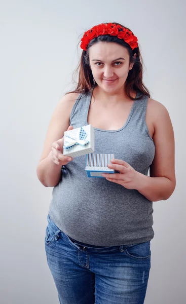 Happy pregnant woman opening gift — Stock Photo, Image